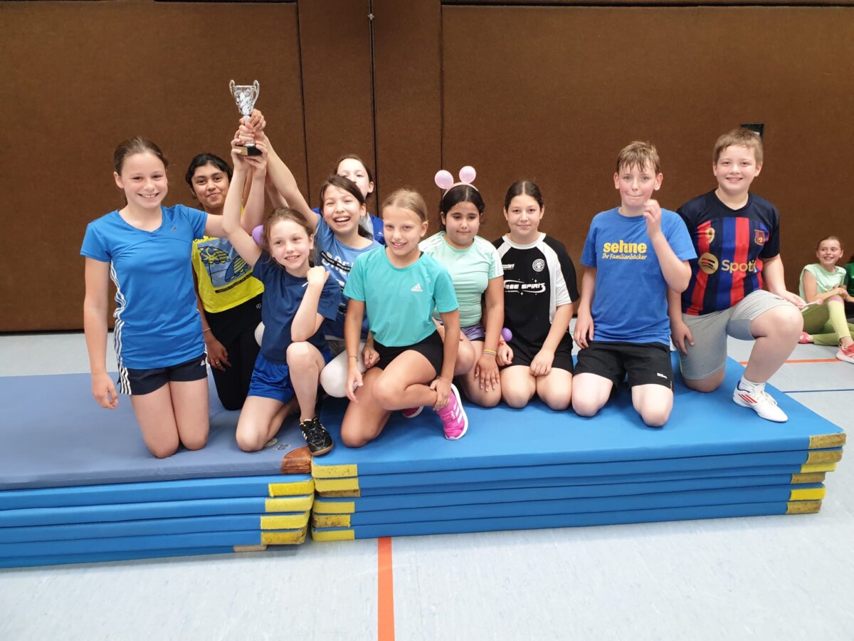 Stufengewinner beim Völkerballturnier posen mit dem Pokal