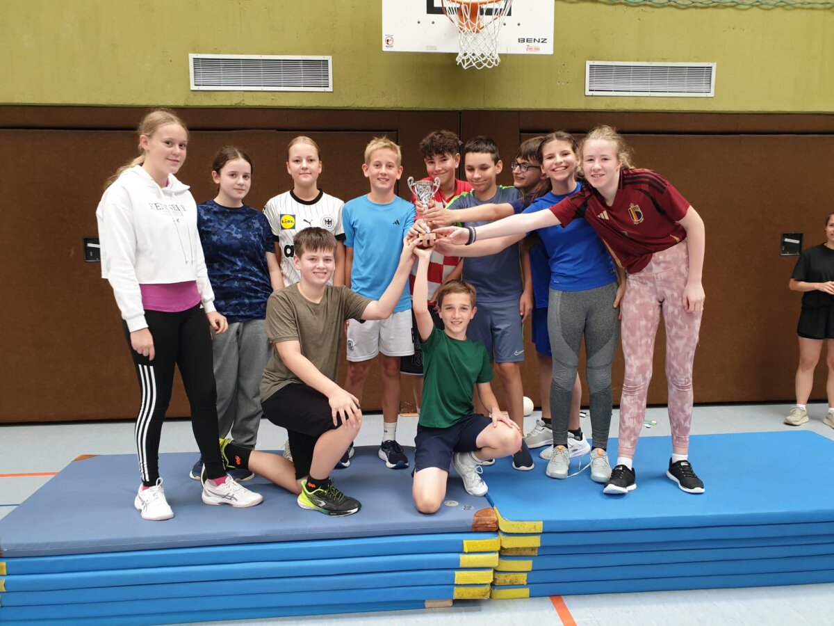 Stufengewinner beim Völkerballturnier posen mit dem Pokal