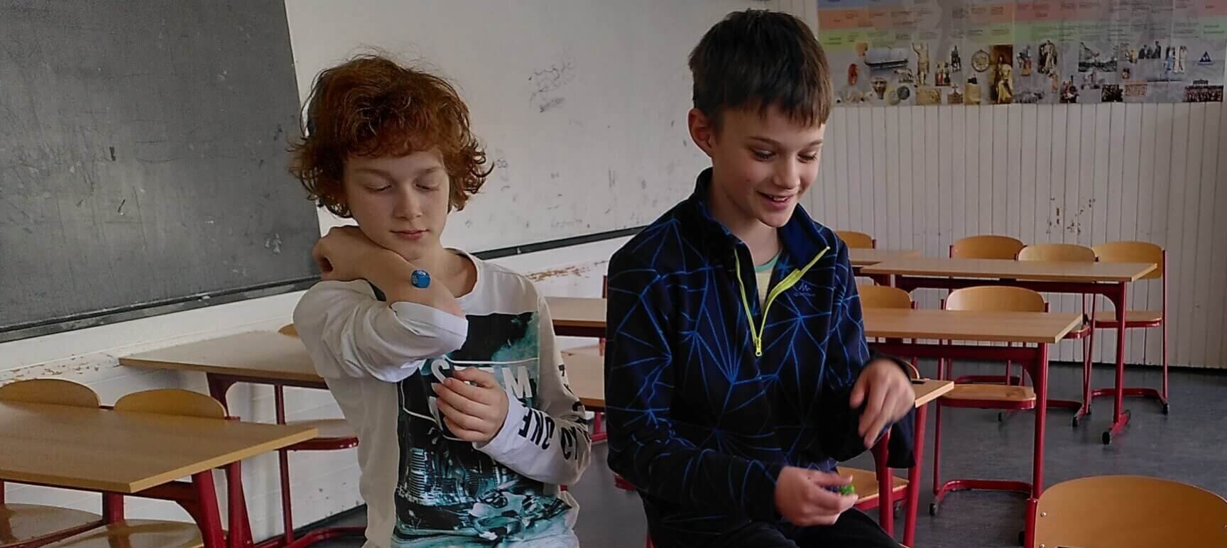 Zwei Jungen spielen gemeinsam ein kooperatives Spiel in einem Klassenzimmer